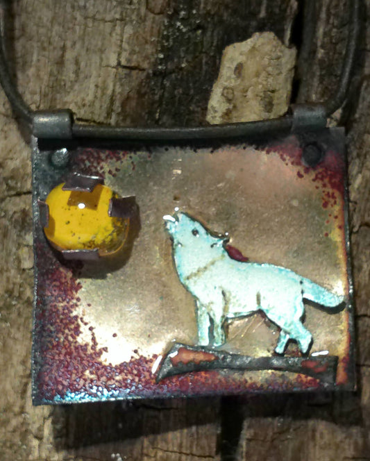 Wolf made of sterling silver hand sawed with yellow glass raindrop on a copper pendant.